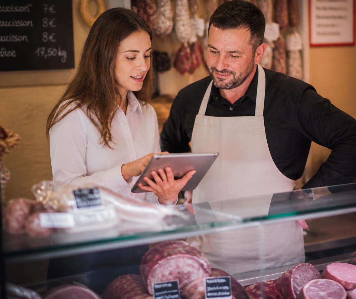 Un conseiller Hexagonia accompagne un fromager sur sa tablette dans sa boutique